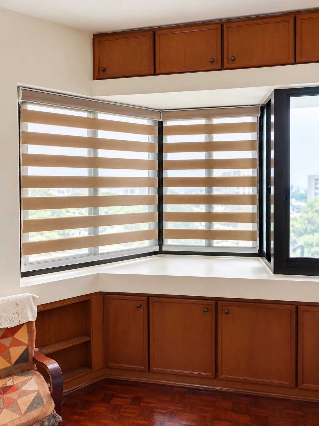 Matching combi blinds fitted to corner windows above built-in wooden cabinets